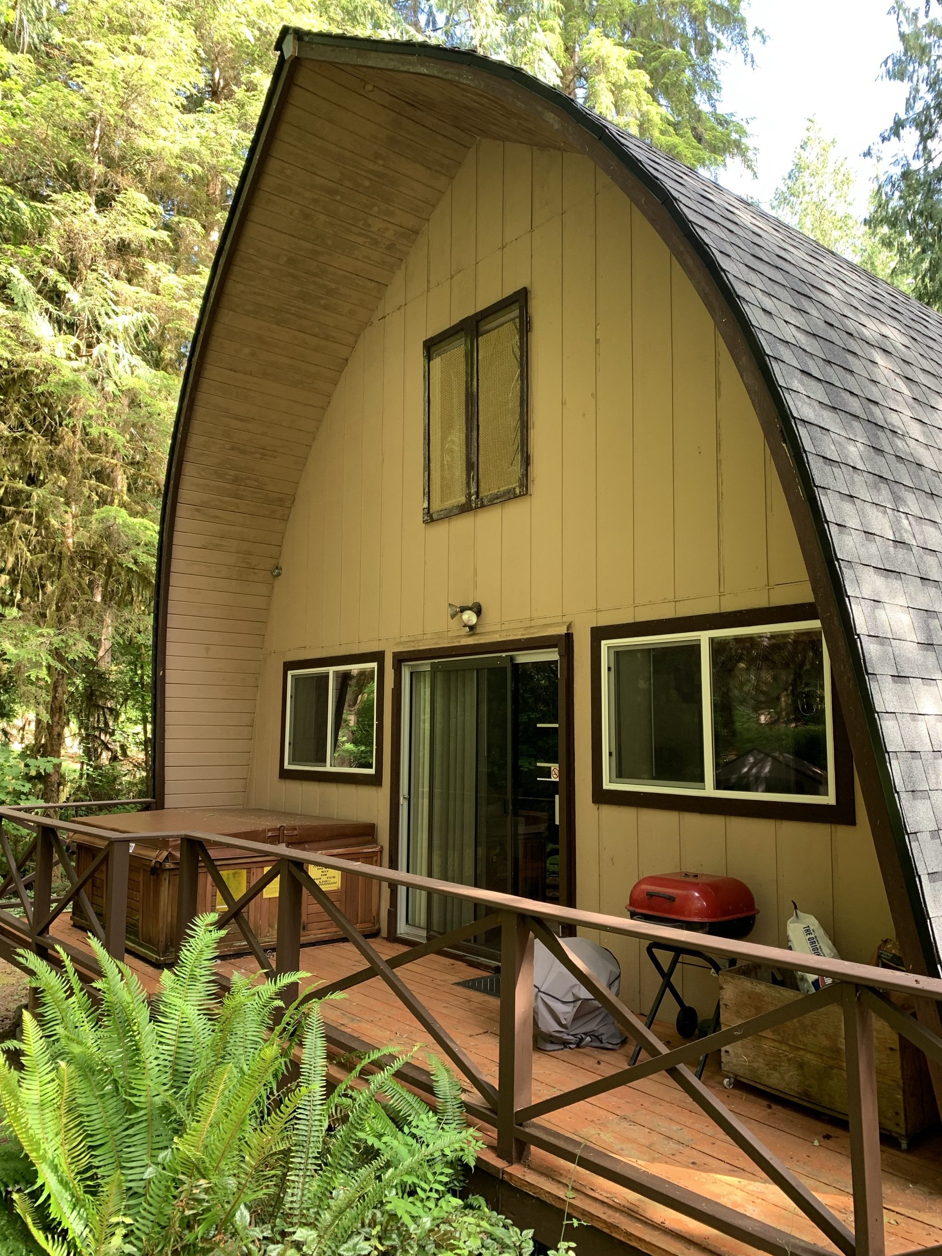 Before: the side exterior of The Arch House with beige siding and brown trim