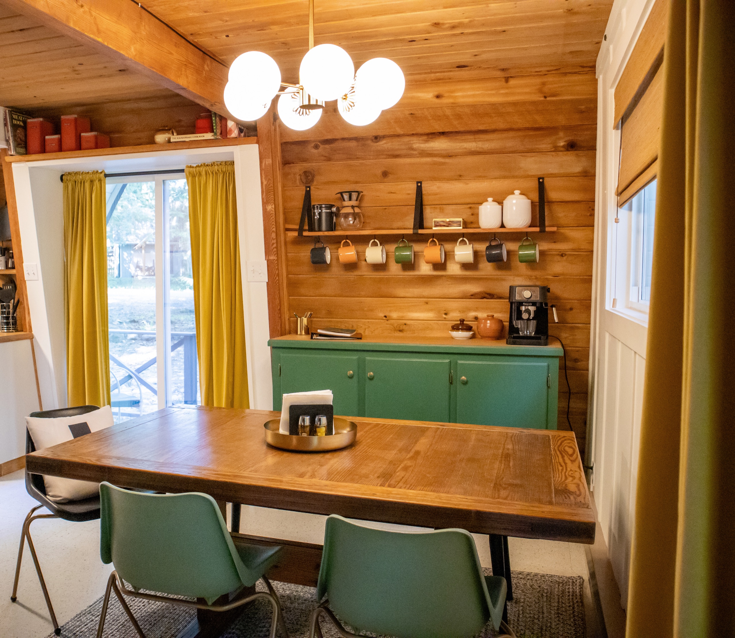 Dining table and green coffee bar with a mug wall and espresso machine