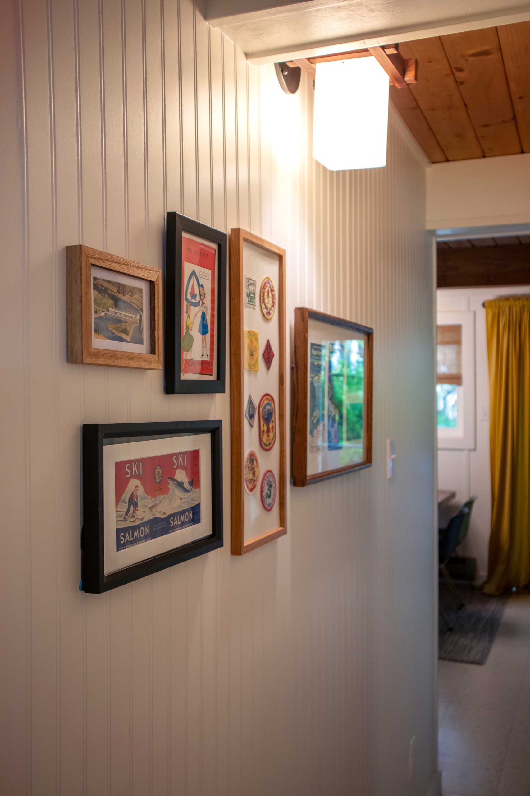 Beadboard hallway with a gallery wall of vintage framed prints